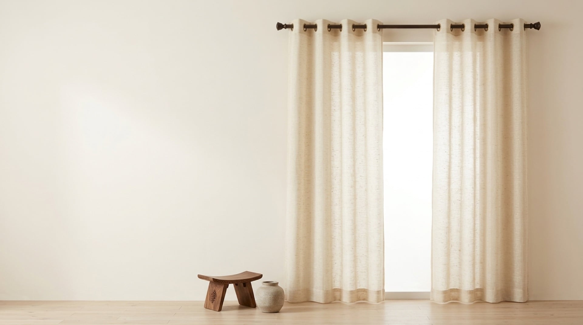 Warm ivory semi-sheer curtains on a walnut rod in a quiet living room